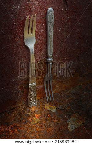 Still life- vintage forks. Rusty metal abstract background