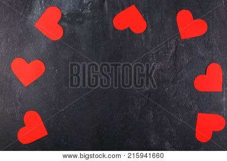 Hearts carved, red of the same size lie along the perimeter arch on a stone background
