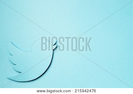 JYVASKYLA FINLAND - OCTOBER 7 2017: Printed Twitter logo on a blue piece of cardboard paper. Negative copy space. Twitter is a social media network founded in 2006. Illustrative editorial.