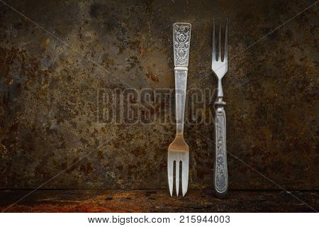 Still life- vintage forks. Rusty metal abstract background