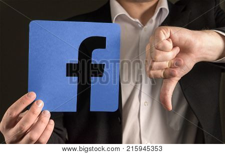 JYVASKYLA FINLAND - JUNE 13 2017: Man in a suit giving thumbs down with a cardboard Facebook logo. Facebook is a popular social media platform launched in 2004. Illustrative editorial.