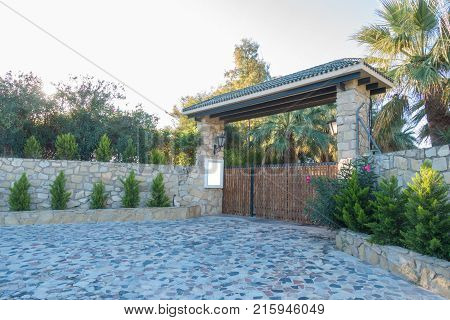 Mock up near the gate to the private house yard. Wooden gates and a high stone fence.