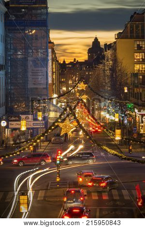 STOCKHOLM SWEDEN - DECEMBER 9 2016: Night view over Kungsgatan a central Stockholm street decorated with Christmas lights during holiday season sunset in background