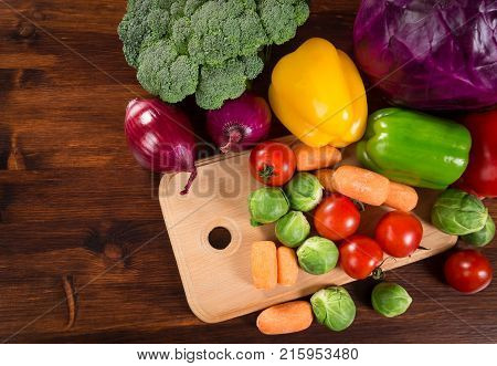 Assortment of fresh vegetales on wooden table, empty space for text