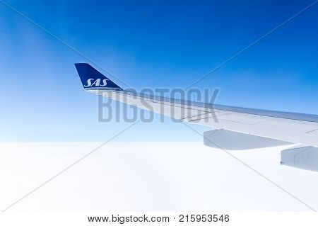 LOS ANGELES USA - AUGUST 17 2017: View to SAS airplane wing during flight through window from cabin. Scandinavian Airlines is the largest airline in Norway Sweden and Denmark. Editorial.