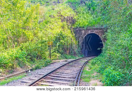 The railway tunnel is surrounded by lush greenery Damodara Ella Sri Lanka.