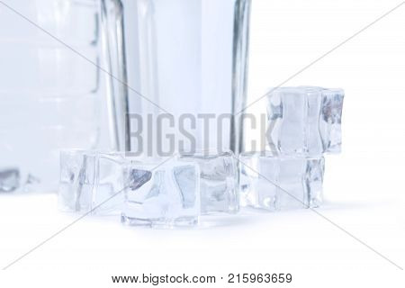 A bottle of water a glass and ice cubes isolated on white background. Pure drinking water with ice.