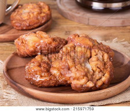 Glazed apple fritters and on a wooden plate