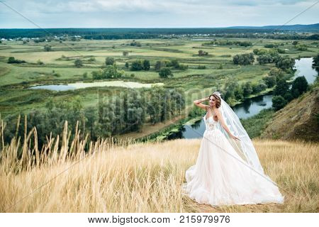 Portrait Of A Young Beautiful Bride On A Background Of A Gorgeous View. Girl In Wedding Dress