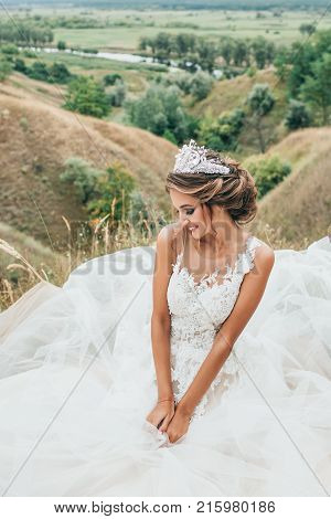 Portrait Of A Young Beautiful Smiling Bride On A Background Of A Gorgeous View Of The River And Fiel
