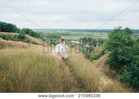 Portrait Of A Young Beautiful Bride On A Background Of A Gorgeous View Of The River And Fields.