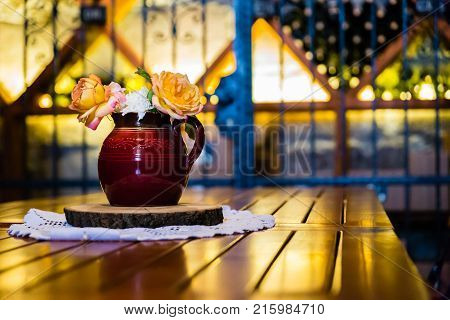 Flowers decorate the table at a Hungarian winery with wine cellar in the background