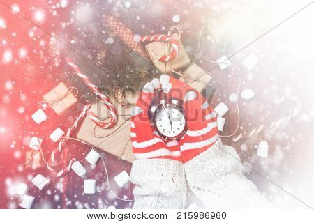 Christmas Composition New Year Woman Or Man Hands In Gloves Hold Alarm Clock. Countdown To Midnight