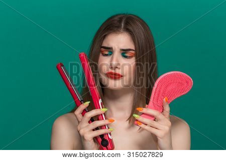 Portrait Of Surprised Beautiful Young Woman With Bright Color Make-up Doing Hair Style Herself With 