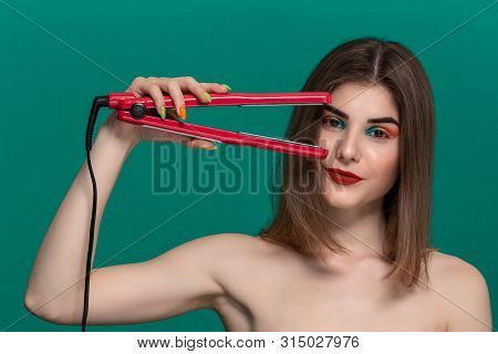 Portrait Of Beautiful Young Woman With Bright Color Make-up Doing Hair Style Herself With A Purple S
