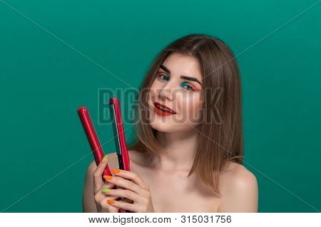 Portrait Of Beautiful Young Woman With Bright Color Make-up Doing Hair Style Herself With A Purple S