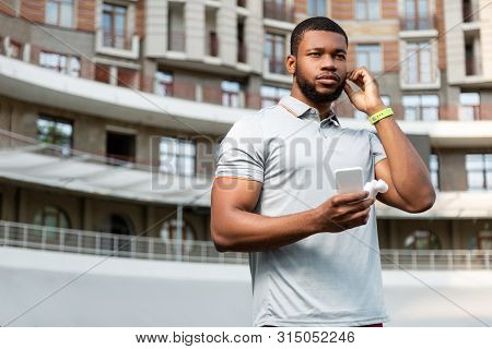 Young Man With A Fitbit Tracker And Smartphone