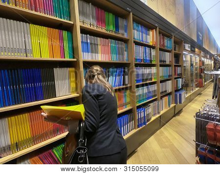 Dubai Uae - July 2019: Buyer Woman Selects Yellow File Folder In The Stationery Store. Buying New Of