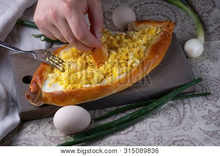 A man mixes ajar khachapuri stuffing. Stuffing from cheese, eggs and butter. Oven cake served for fo
