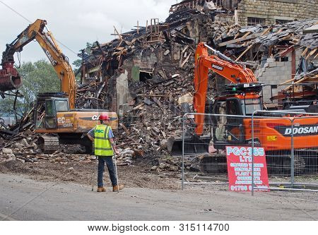 Hebden Bridge, West Yorkshire, United Kingdom - 2 August 2019: A Man On Crutches In Protective Work 