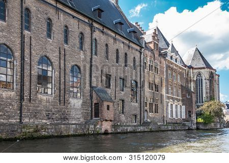 Gent, Flanders, Belgium -  June 21, 2019: Brown Stone University Building Het Pand Bordering Leie Ri