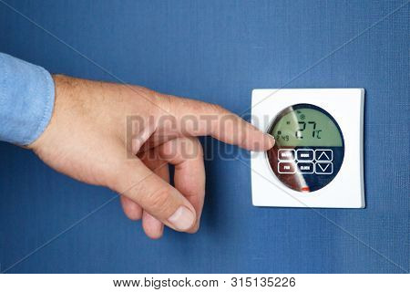 Man Hand Turn On Air Condition Remote Switch. Man Operating Air Conditioner.