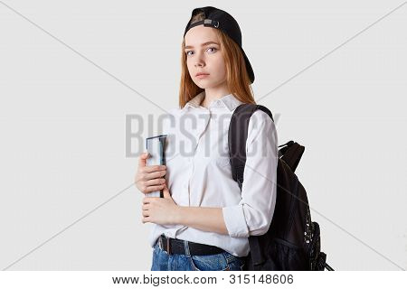 Horizontal Shot Of Student Girl Standing Isolated Over White Background, Holding Paper Folders In Ha