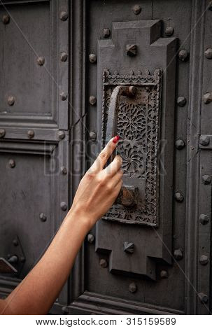 Woman Hand Knoking At The Ancient Door With The Door Knocker