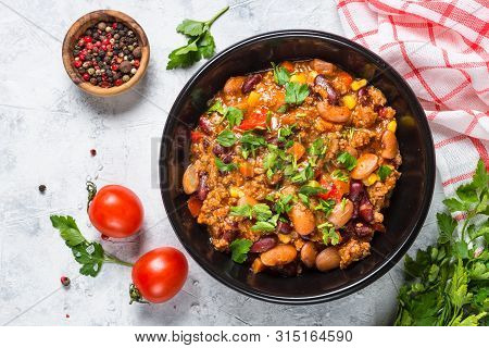 Chili Con Carne From Meat, Beans And Vegetables In Black Plate On Stone Table. Traditional Mexican F