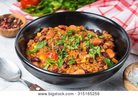 Chili Con Carne From Meat, Beans And Vegetables In Black Plate On Stone Table. Traditional Mexican F