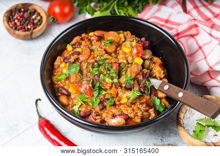 Chili Con Carne From Meat, Beans And Vegetables In Black Plate On Stone Table. Traditional Mexican F
