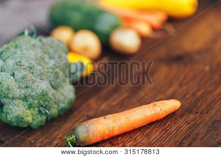 Fresh Salubrious Colourful Vegetables On Wooden Background, Carrot In Focus, Potatoes, Broccoli, Zuc