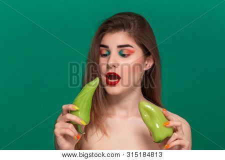 Closeup Portrait Of Beautiful Young Woman With Bright Color Make-up Holding Green Pepper Standing Is