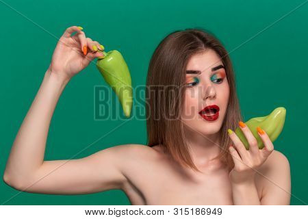 Closeup Portrait Of Beautiful Young Woman With Bright Color Make-up Holding Green Pepper Standing Is