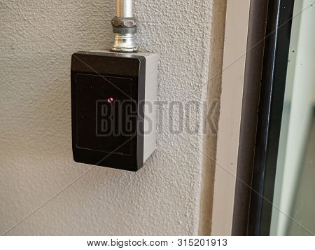 Black Keycard Reader Outside Of A Entryway With A Red Light
