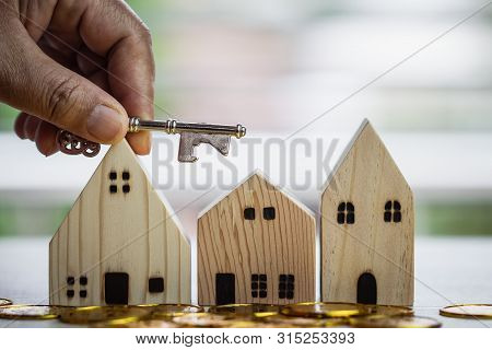 Ownership Hold Key Against House With Miniature Home For Protect And Insurance Document With White B
