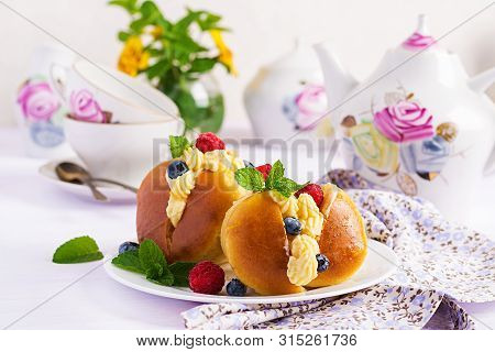 Rum Baba Decorated With Whipped Cream And Fresh Raspberry, Blueberry. Savarin With Rum, Cream And Be