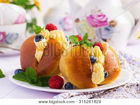 Rum Baba Decorated With Whipped Cream And Fresh Raspberry, Blueberry. Savarin With Rum, Cream And Be