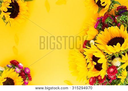 Sunflowers And Aster Fresh Flowers Frame , Top View On Yellow Background With Copy Space, Naturall F