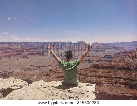 Sitting On The Edge Of A Deep Descent In The Beautiful Grand Canyon National Park