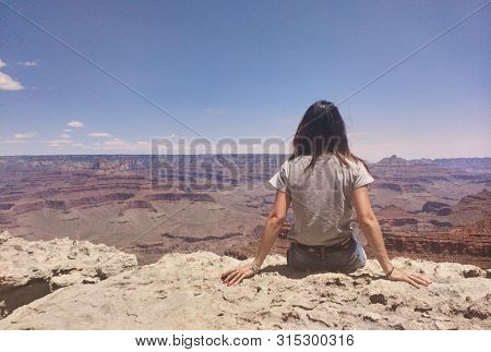 Sitting On The Edge Of A Deep Descent In The Beautiful Grand Canyon National Park