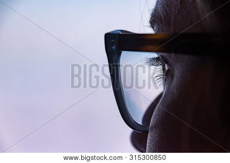 Close Up Of Eye With Glasses Looking Thoughtfully Out Of The Window
