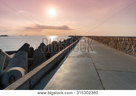 North Pier With Breakwaters, Sunset Seascape. Tetrapods Along Edges Of Pier. Beautiful Evening Seasc