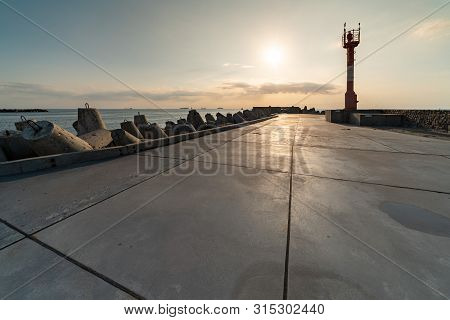 North Pier With Breakwaters, Sunset Seascape. Tetrapods Along Edges Of Pier. Beautiful Evening Seasc