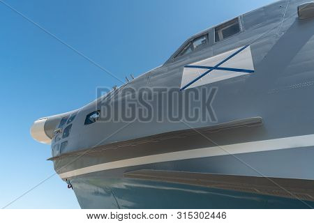 Nose Of Military Airplane With Ensign Of Russian Navy. Copy Space. Blue Sky Russian Background