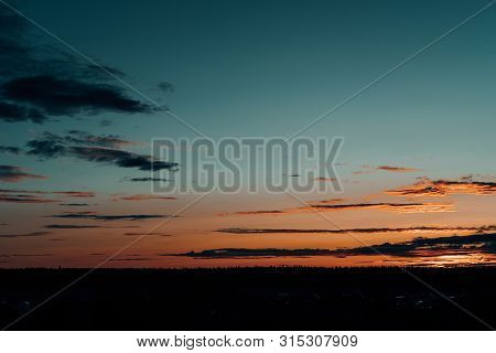 Evening Sky At Sunset Background. Dark Clouds Hanging Above Horizon. Majestic Cloudscape In Blue, Or
