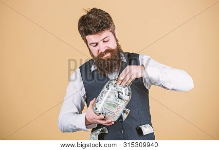 Hiding Money For Future Use. Bearded Man Investing Money From Glass Jar For Future Profits. Business