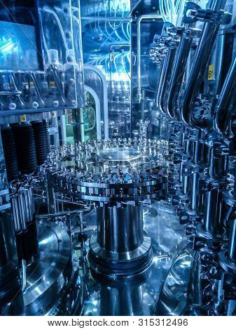 Parts Of Filling Bottles Machine In Drinking Production Factory.