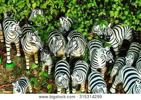 Many Zebra Statues In Asia Thailand Buddhist Temple,group Of Zebra Statue Background In The Garden.