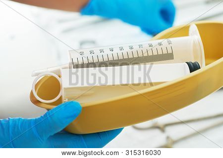 Syringe For Gastric Lavage In The Hands Of A Nurse In The Operating Room. Nurse Preparing Medical In